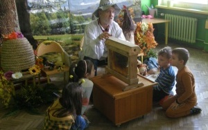 Uczniowie oglądają pszczoły w szklanym ulu.